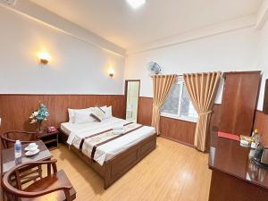 1 dormitorio con cama, mesa y ventana en Nhat Minh Hotel - Etown and airport en Ho Chi Minh