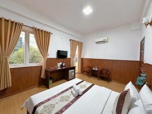 um quarto de hotel com uma cama e uma televisão em Nhat Minh Hotel - Etown and airport em Ho Chi Minh