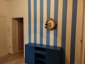 une armoire bleue avec un miroir sur un mur rayé dans l'établissement Bilocale primo piano, à Piombino