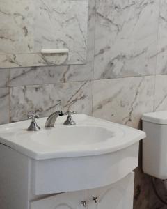 een badkamer met een witte wastafel en een toilet bij Habano Apart in Esquina