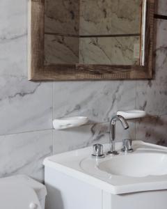 a bathroom with a sink and a mirror and a toilet at Habano Apart in Esquina