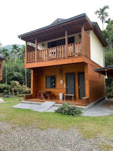 a large wooden house with a balcony on top at Cabin of Sun Moon Lake in Yuchi