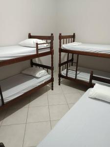 two bunk beds in a room with a white floor at Casa com Piscina e churrasqueira/ mar casado in Guarujá +37 photos