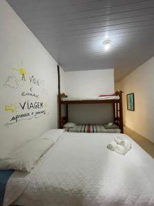 a bedroom with a bed with a white bedspread at Pousada Kaimana - Maresias in Maresias