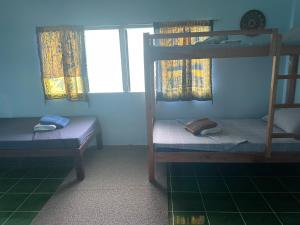 a room with two bunk beds and a window at Blue Lagoon Guest house for Backpakers in Puerto Galera