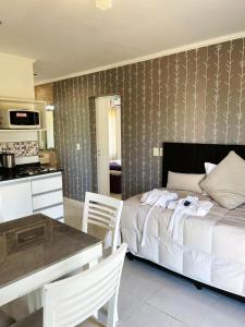 um quarto com uma cama, uma mesa e uma cozinha em DINASTIE APART HOTEL em Chajarí
