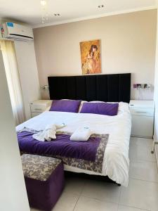 ein Schlafzimmer mit einem großen Bett mit zwei Handtüchern darauf in der Unterkunft DINASTIE APART HOTEL in Chajarí