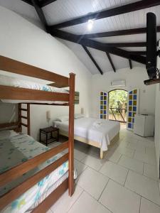 1 dormitorio con 2 literas y balcón en Pousada Kaimana - Maresias en Maresias