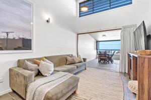 uma sala de estar com um sofá e uma mesa em Sea Spray - Lennox Head em Lennox Head