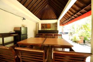 a dining room with a wooden table and a refrigerator at Tori Inn in Sanur