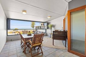 a dining room with a table and chairs and a window at Sea Spray - Lennox Head in Lennox Head