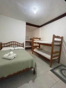 um quarto com 2 camas e 2 beliches em Pousada Kaimana - Maresias em Maresias