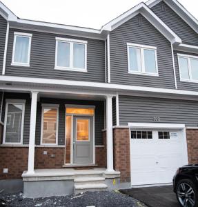 uma casa cinzenta com uma garagem branca em TN Homes em Ottawa