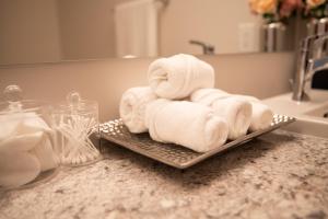 uma pilha de toalhas numa bandeja no balcão da casa de banho em TN Homes em Ottawa
