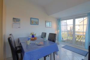 uma sala de jantar com uma mesa azul e cadeiras em KI22-15 Haus Seeadler em Dorum Neufeld
