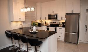 uma cozinha com um balcão preto e um frigorífico em TN Homes em Ottawa