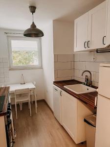 a kitchen with a sink and a table and a window at Wohnen im 3 Ländereck! Essen, Mülheim, Oberhausen! BS2HL in Essen