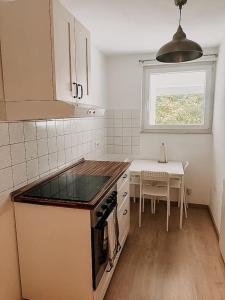 a kitchen with a stove and a table with a window at Wohnen im 3 Ländereck! Essen, Mülheim, Oberhausen! BS2HL in Essen
