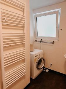 a bathroom with a washing machine and a window at Wohnen im 3 Ländereck! Essen, Mülheim, Oberhausen! BS2HL in Essen