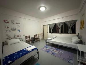 a bedroom with two beds and a table and chairs at Madam Guesthouse in Krabi