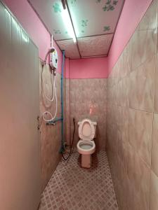 a bathroom with a toilet with a pink ceiling at Madam Guesthouse in Krabi