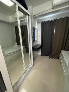 Zimmer mit einem Spiegel, einem Bett und einem Fenster in der Unterkunft Sea residence reyplace in Manila