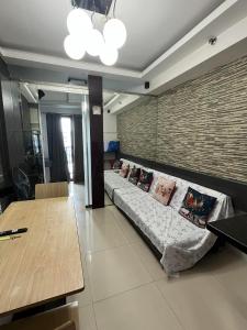 ein Wohnzimmer mit einem Sofa mit Kissen darauf in der Unterkunft Sea residence reyplace in Manila
