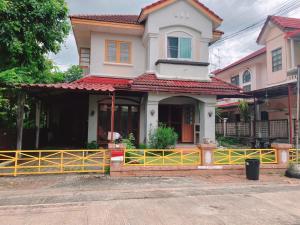 une maison avec une clôture jaune devant elle dans l'établissement Lake home, à Ban Ko