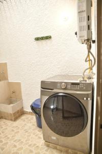 een wasmachine in een badkamer met een toilet bij la casa del solo envigado in Envigado