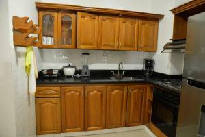 een keuken met houten kasten en zwarte aanrechtbladen bij la casa del solo envigado in Envigado