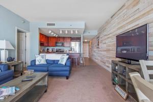 a living room with a blue couch and a tv at Laketown Wharf 1226 -2BD+Bunks, Amazing Gulf Views in Panama City Beach