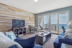 a living room with a couch and a television and a table at Laketown Wharf 1226 -2BD+Bunks, Amazing Gulf Views in Panama City Beach