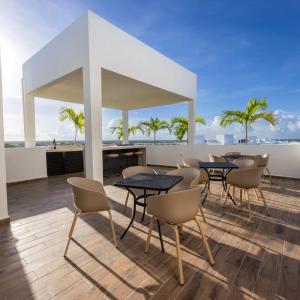 a dining room with tables and chairs and the ocean at Mya Black Diamond 202 in Playa del Carmen