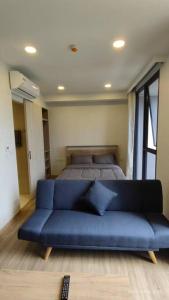 Sofá azul en una habitación con cama en 普吉岛Laguna海滩豪华天际泳池公寓，奢华体验与休闲之选 en Phuket