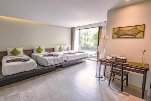 Habitación con 2 camas y escritorio. en SriLanta Resort and Spa en Ko Lanta