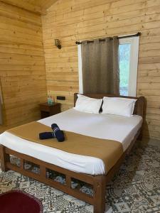 Cama en habitación de madera con cama grande sidx sidx sidx sidx en Peles Windsong wooden cottages, en Benaulim