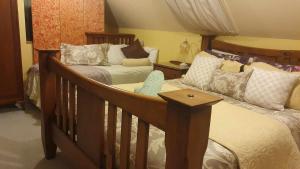 ein Schlafzimmer mit 2 Betten und einem Kinderbett in der Unterkunft Century House B & B flatlette in Oamaru