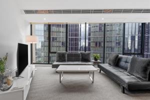 uma sala de estar com um sofá e uma televisão em Southbank Two Bedroom Apt - 2202 em Melbourne