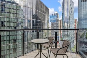 a table and chairs on a balcony with a view of a city at Southbank Two Bedroom Apt - 2202 in Melbourne