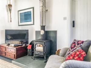 a living room with a stove and a couch at Llys Bychan in Granston