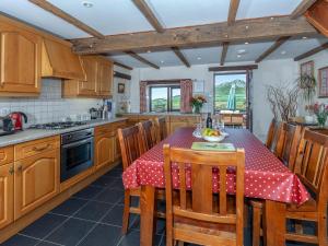 una cocina con una mesa con un mantel rojo. en Carn Llidi Cottage en St. Davids