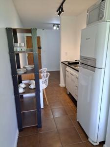 a kitchen with a white refrigerator and a counter at Studio 109-comfortable, practical, great location in Brasilia