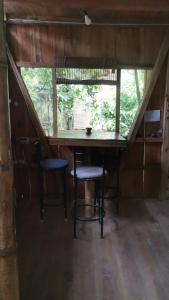 - une table et deux chaises dans une chambre avec fenêtre dans l'établissement Centro Arte Terapéutico San Isidro Glamping, à San Isidro