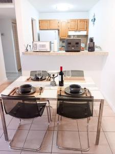 cocina con mesa y 2 sillas con copas de vino en Welcome to Miami ONE BEDROOM FOR RENT UNA HABITACION EN RENTA en Miami