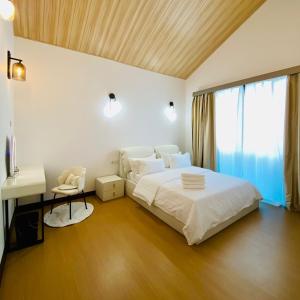 Kampong Kundassan的住宿－929 Villa, kundasang，一间卧室配有一张床、一张书桌和一个窗户。