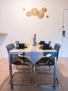 una mesa de comedor con sillas y una mesa con tazones. en Welcome to Miami ONE BEDROOM FOR RENT UNA HABITACION EN RENTA en Miami