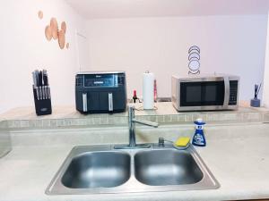encimera de cocina con fregadero y microondas en Welcome to Miami ONE BEDROOM FOR RENT UNA HABITACION EN RENTA en Miami