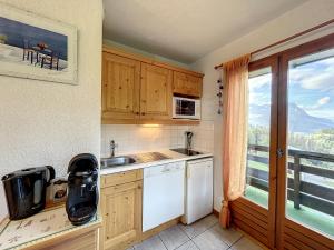eine kleine Küche mit einem Waschbecken und einem Fenster in der Unterkunft Appartement Combloux, 2 pièces, 6 personnes - FR-1-560-44 in Combloux