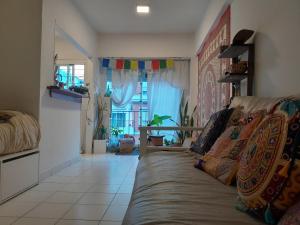 un salon avec un canapé et une fenêtre dans l'établissement Departamento centro Mar del Plata-1 cuadra del mar- monoambiente-balcón calle., à Mar del Plata