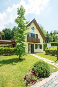 a house with a tree in the yard at Case Vacanza Orchidea in Coreglia Antelminelli